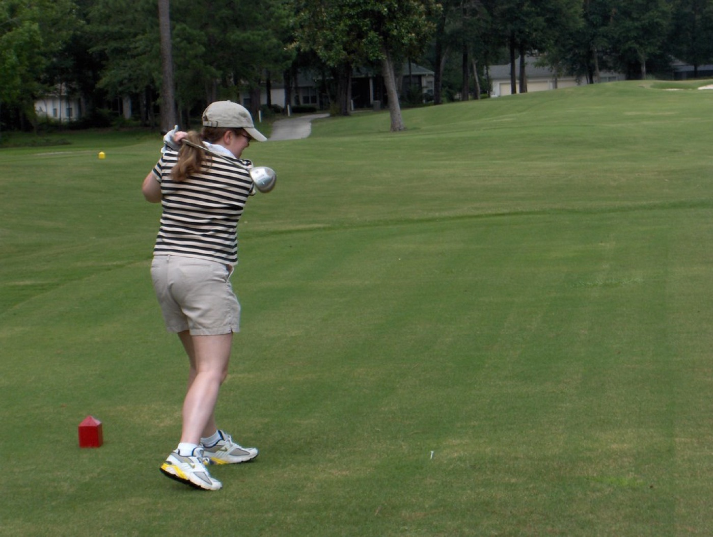 A golfer mid-swing on a lush green fairway