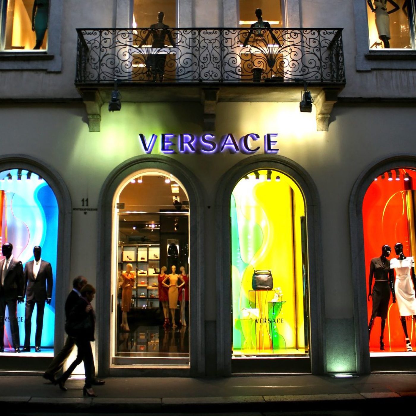 A luxury designer boutique storefront lit up in the evening